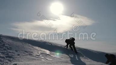 游客攀登一座山雪崖.. 伸出援助之手。 人们互相帮助。 团队合作，团队合作理念